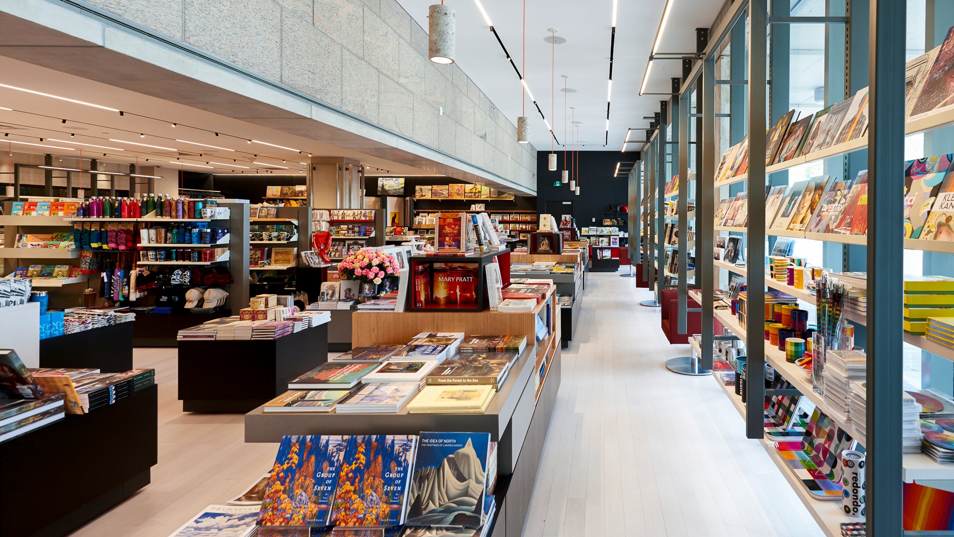 Rayonnages de livres colorés dans la Boutique et fenêtres à droite.